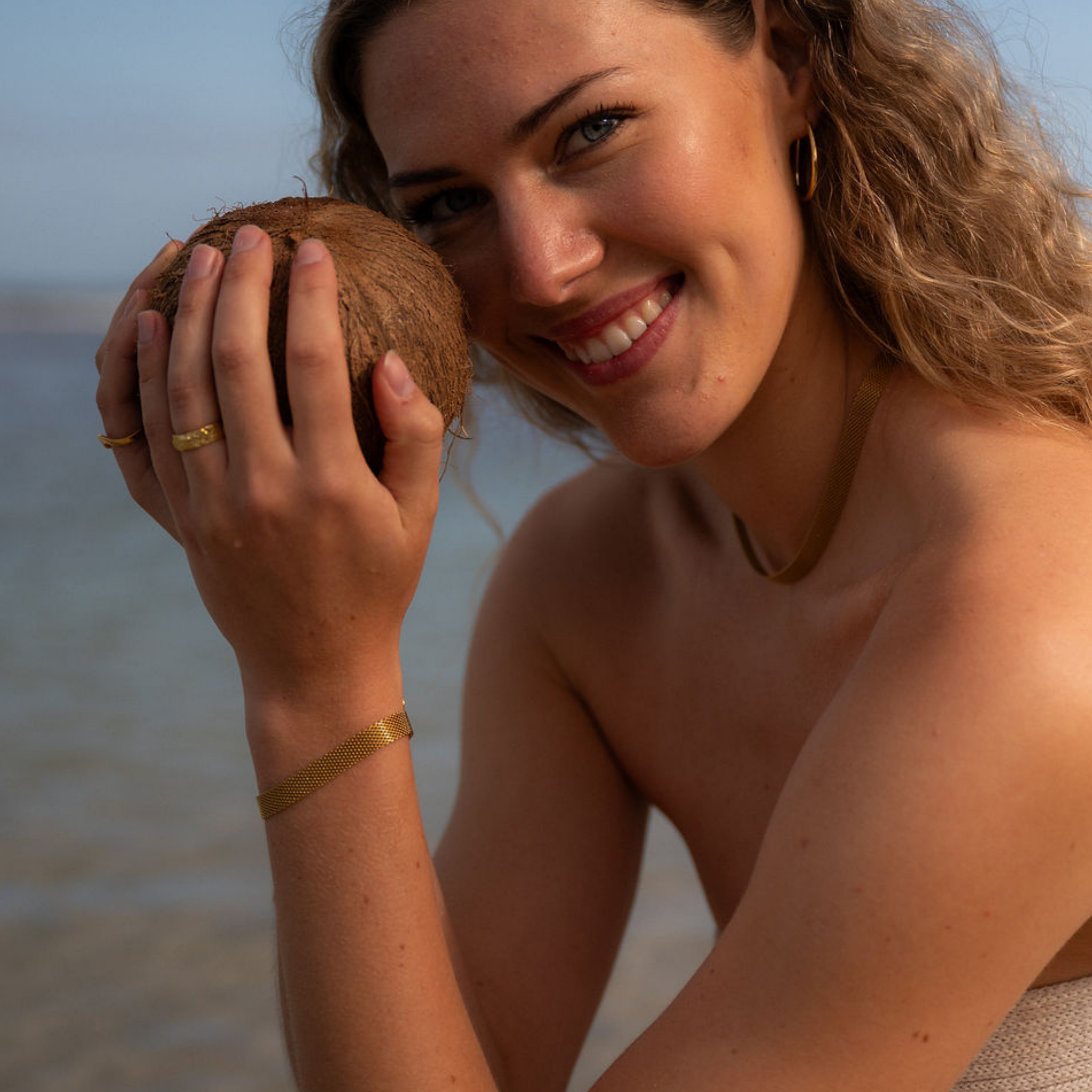 Woman holding a coconut on a beach