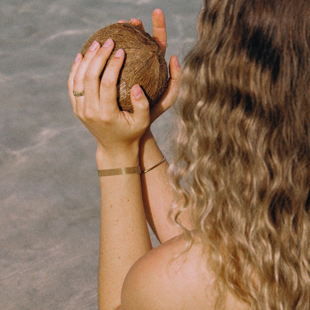Person holding a coconut on a beach